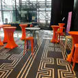 Orange Tolix stools and tables in a lobby.
