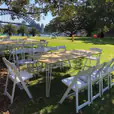 Our timber top hairpin table with some white stackable chairs being used at an outdoor park next to the harbour bridge