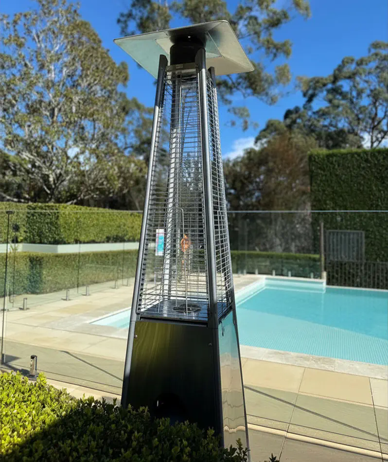 Outdoor pyramid gas heater beside a pool and landscaped entertaining area with visible flame heating element