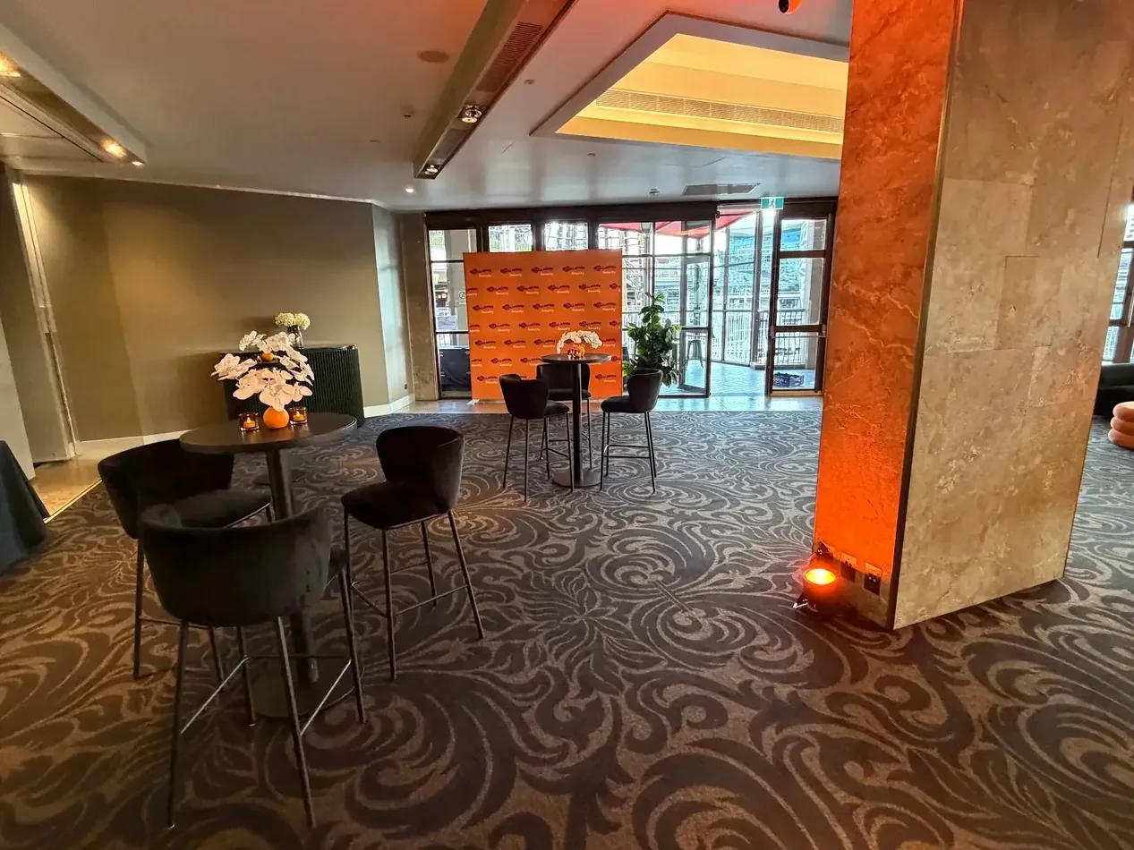 Blue par can uplighting illuminating an indoor event stage and feature wall