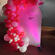 Pink and white balloon display with coloured uplighting and illuminated backdrop for an 18th birthday event