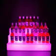 A hireable glow bottle shelf display with a vibrant purple light.
