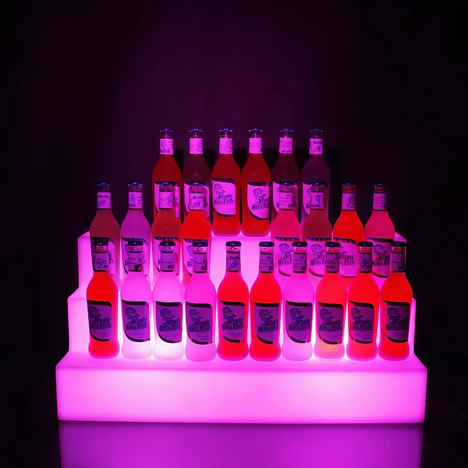 A hireable glow bottle shelf display with a vibrant purple light.