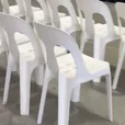 Rows of white plastic stackable chairs shown in the chair hire video