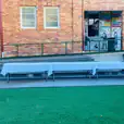 A plastic trestle table set up on a grassy area in front of a building.