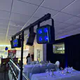 Portable event lighting rig with blue LED light fixtures illuminating a decorated dining and function venue