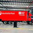 Portable PA system with speakers on stands and microphones set up in a warehouse event space in front of a large branded truck