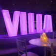 Large purple glow letters spelling the word villa