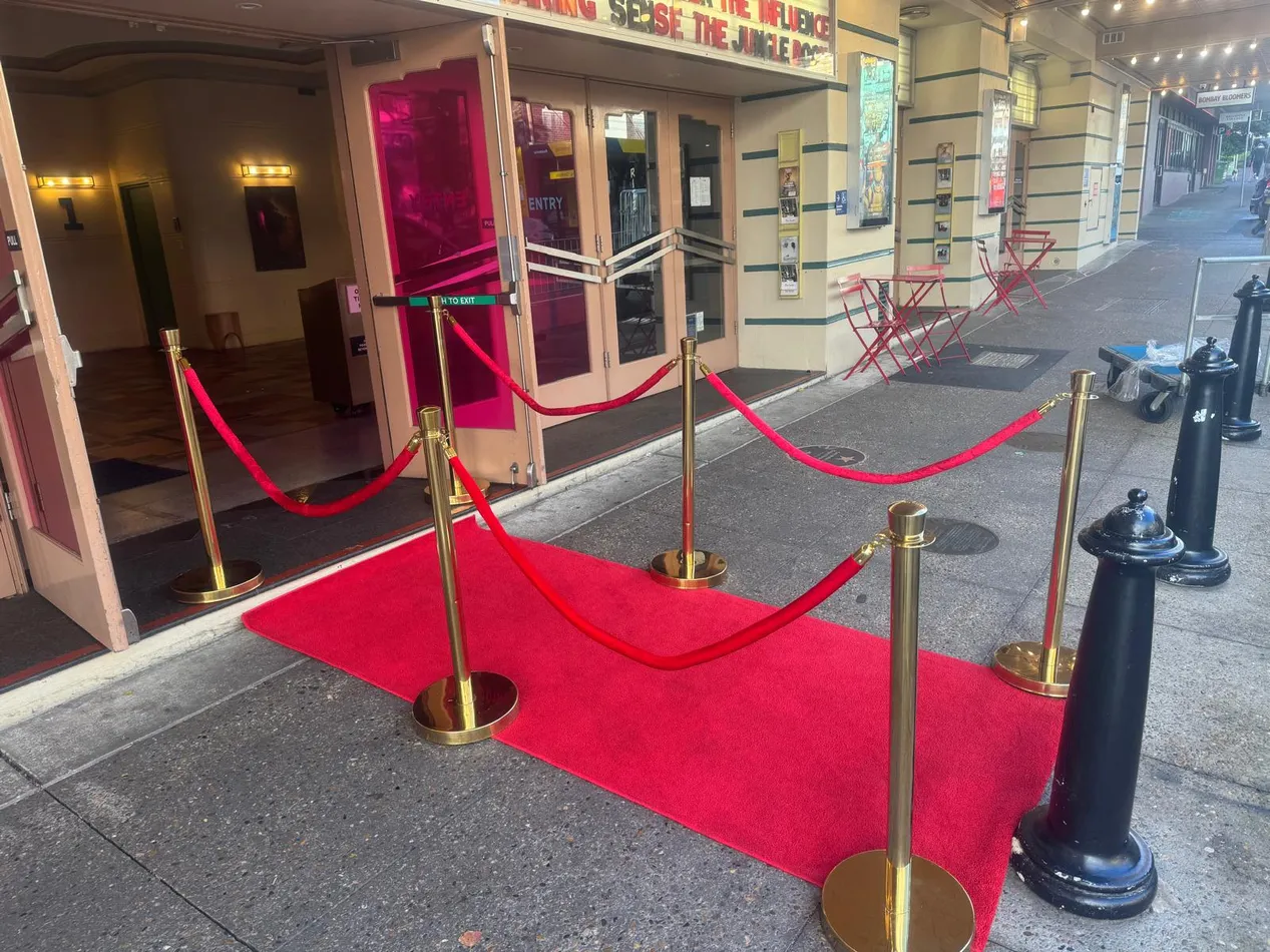 Three metre red carpet runner laid at a theatre entrance and lined with gold bollards and red velvet ropes