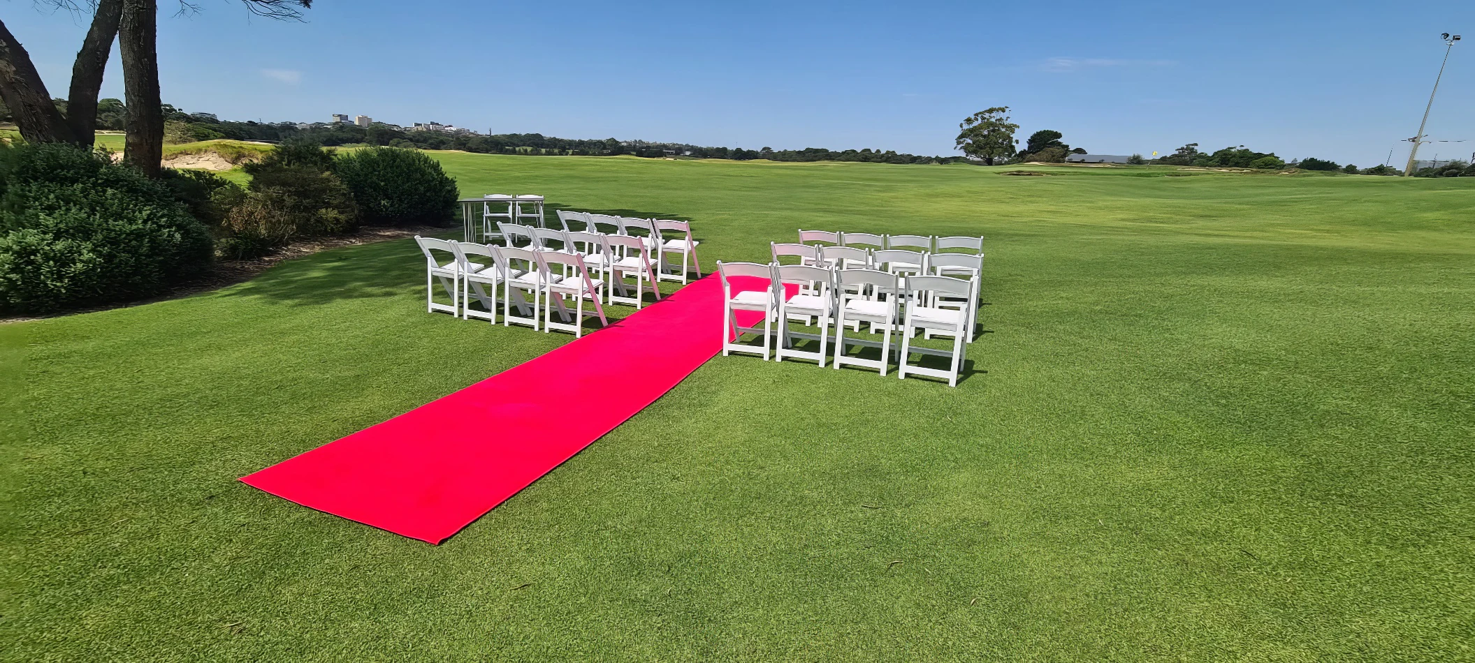 A stunning wedding ceremony set up on a golf course, complete with a luxurious 6m red carpet hire.