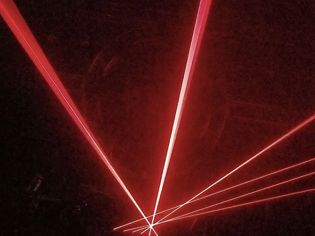 A red laser light is hired and shown in the dark.