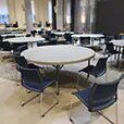 Conference room setup with round banquet tables and chairs arranged for group seating in a large indoor space