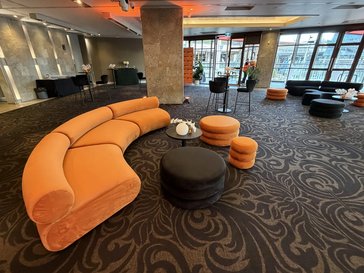 Sienna Apollo curved lounges with small and large ottomans and a black velvet ottoman at an event