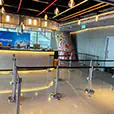 Silver tensa barrier queue setup positioned in front of an event registration counter inside a modern venue foyer