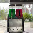 Two soda dispensers, one functioning as a slushie machine from Package 2, are sitting on top of a table.