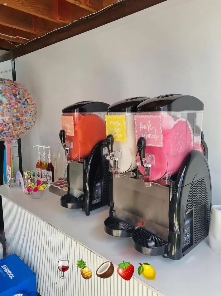 Two slushie machines on a table next to each other, serving a total of 180 drinks.