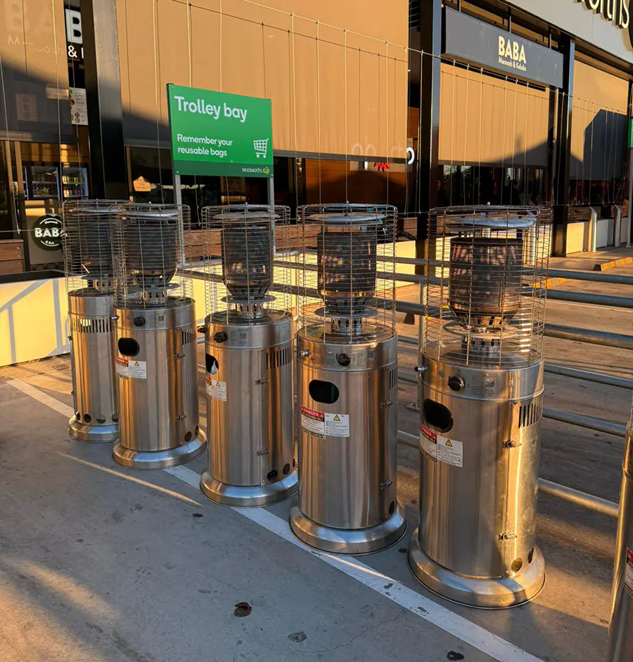 Stainless steel outdoor area heaters lined up outside a shopping centre entrance for event and winter heating use