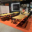 Timber banquet tables with black folding chairs arranged inside a retail market activation and dining space
