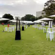A group of tables and chairs set up on a grassy area, available for Market Umbrella Hire.