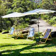 Three deckchairs with market umbrellas on a grassy area for hire.
