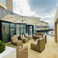 A balcony with lounge chairs and umbrellas overlooking the water, perfect for Market Umbrella Hire.