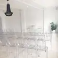 A room filled with Victorian ghost chairs and a chandelier.