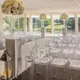 A Victorian ghost chair hire for an elegant wedding ceremony, adorned with beautiful flowers.