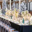 A Victorian-themed table set up for a Christmas party, complete with elegant ghost chairs.