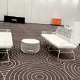 A white table and chairs in a room with a circular pattern.