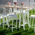 Multiple white bentwood bar stools at a wedding cocktail event with natural timber furniture