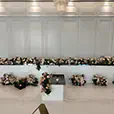 White bridal table with soft pink and white floral arrangements in an elegant wedding reception venue with decorative wall panelling