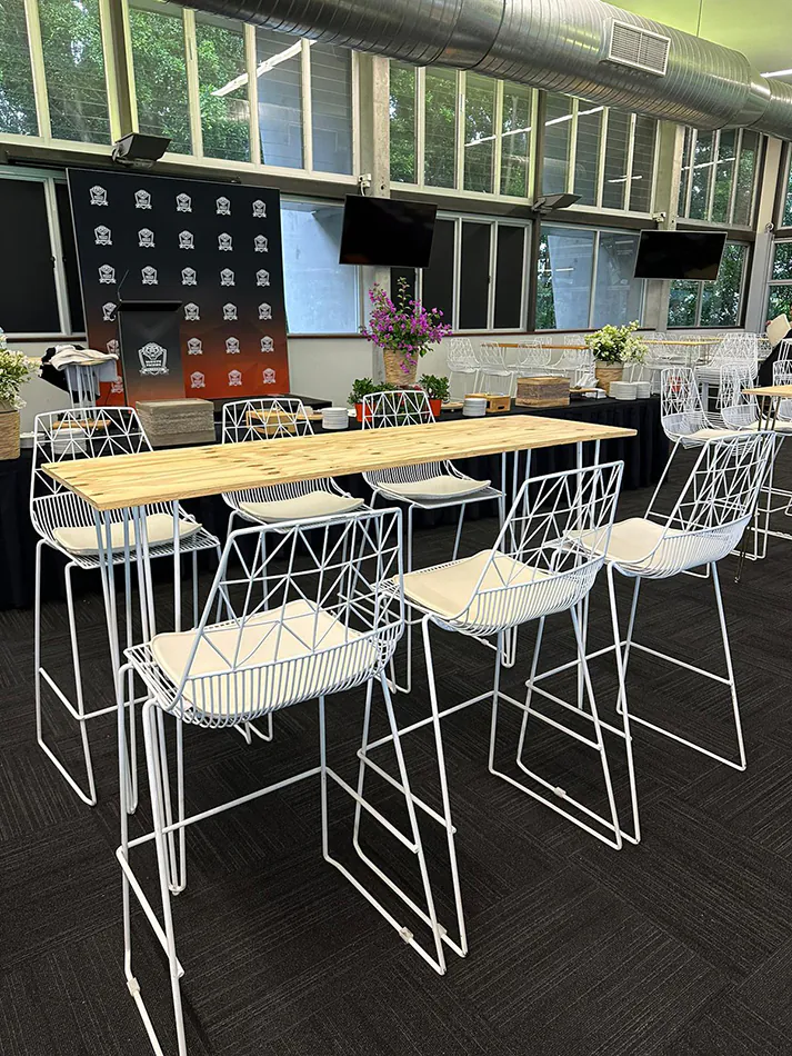 A white hairpin high bar table with timber top hired for a function
