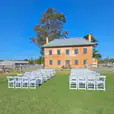 A wedding ceremony set up in front of a pristine white brick building.