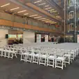 A large conference room with white Gladiator chairs and a large screen.
