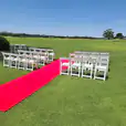 A wedding ceremony set up on a golf course with White Padded Folding Chair Hire.