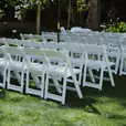 White folding chairs set up for a wedding ceremony, available for White Padded Folding Chair Hire.