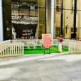 A lobby with a white picket fence and green grass.
