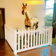 A horse statue in an office with a white picket fence available for hire.