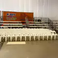 White plastic chairs in a warehouse with a truck in the background.