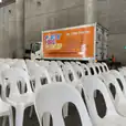 White plastic chairs stacked in a warehouse.