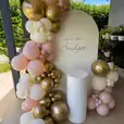 White ribbed plinth placed in front of a custom birthday backdrop, decorated with gold, blush pink, and ivory balloon garland for an 18th birthday celebration.
