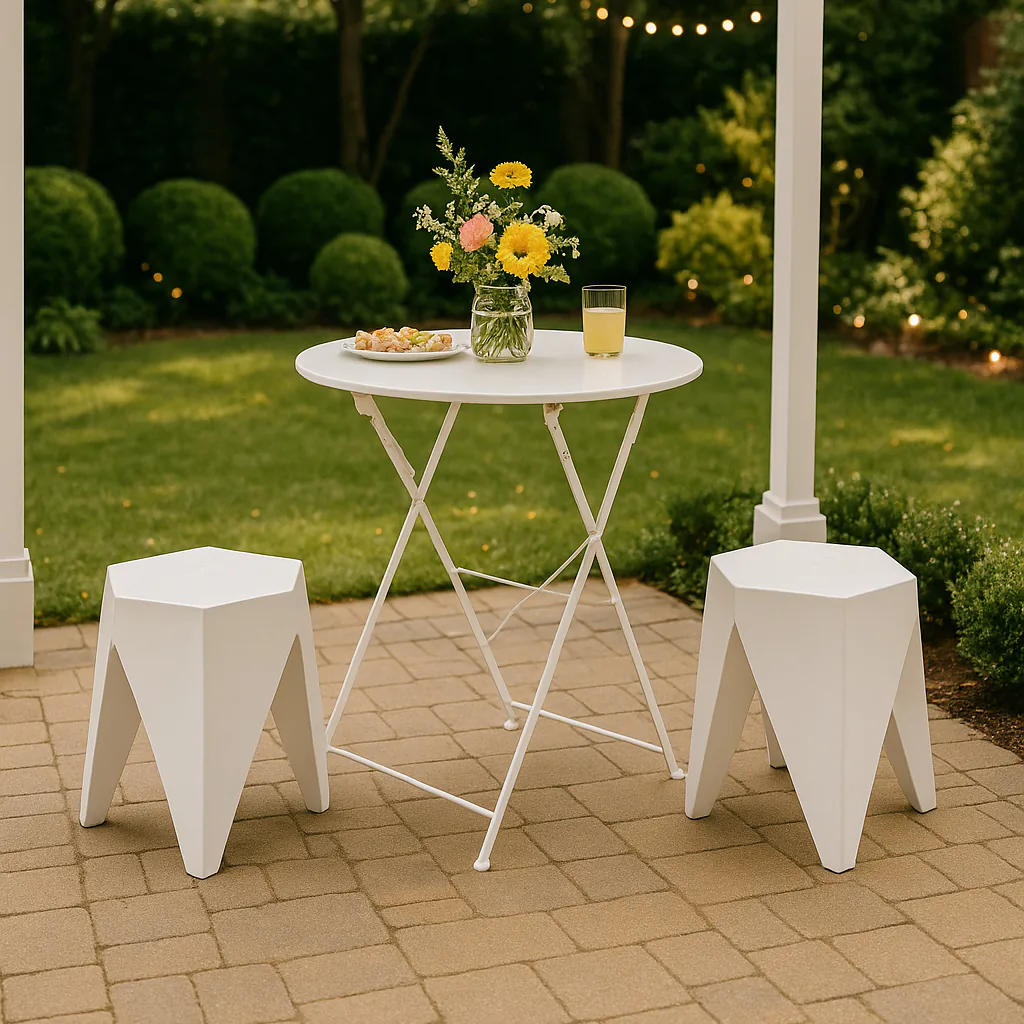 White puzzle stools arranged around a small white cocktail table in an outdoor garden setting, styled under a pergola with bunting and soft decorative lighting for a relaxed event atmosphere.