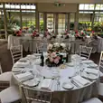 A wedding reception set up with white tables and White Tiffany chair hire.