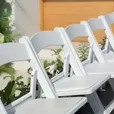 Rows of white padded folding wedding chairs shown in the chair hire video
