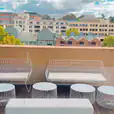 A breathtaking view of the city from the rooftop of a hotel, with a white arrow lounge seating arrangement for hire.