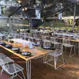 A white tent set up with tables and chairs, including White Arrow Chair Hire.
