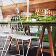 A white table and chairs with green grass in the background.