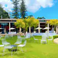 A large lawn with white tables and chairs available for White Chair Hire.
