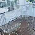 A white table and chairs on a wooden deck, perfect for your next cocktail party.