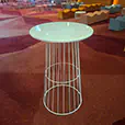 White wire cocktail table hire displayed in an indoor event venue with patterned carpet, lounge seating and ambient lighting in the background